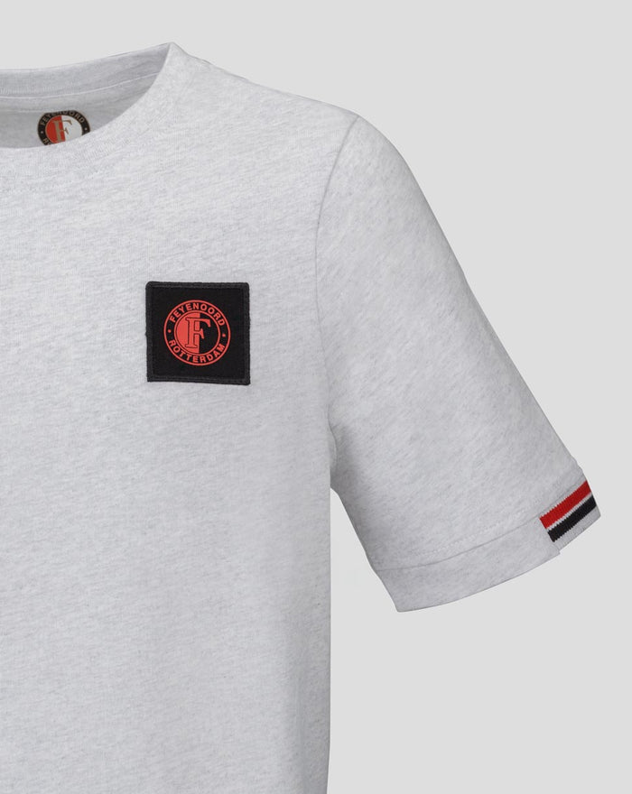 Close-up of gray Feyenoord Junior T shirt showing black patch with red circular emblem on chest