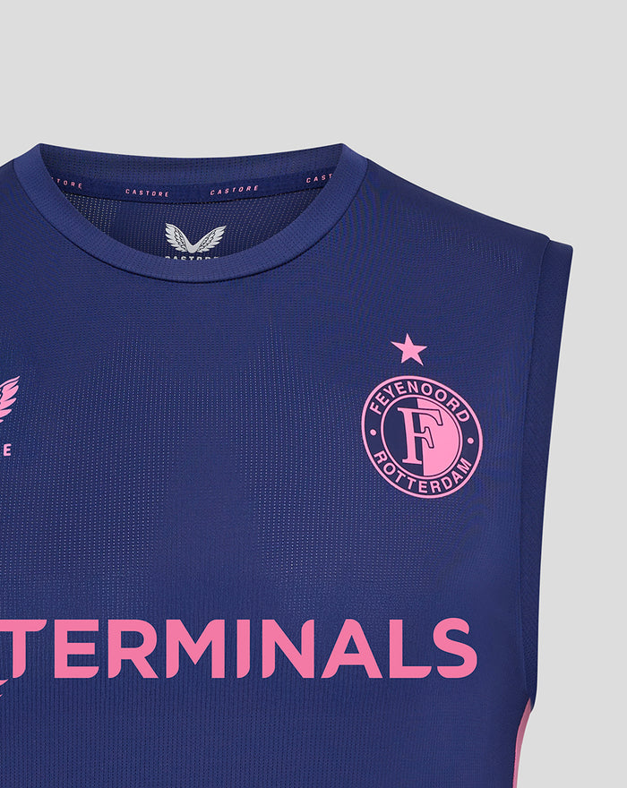 Front view of blue sleeveless training shirt with pink Feyenoord crest on the left chest and pink Castore logo on the right