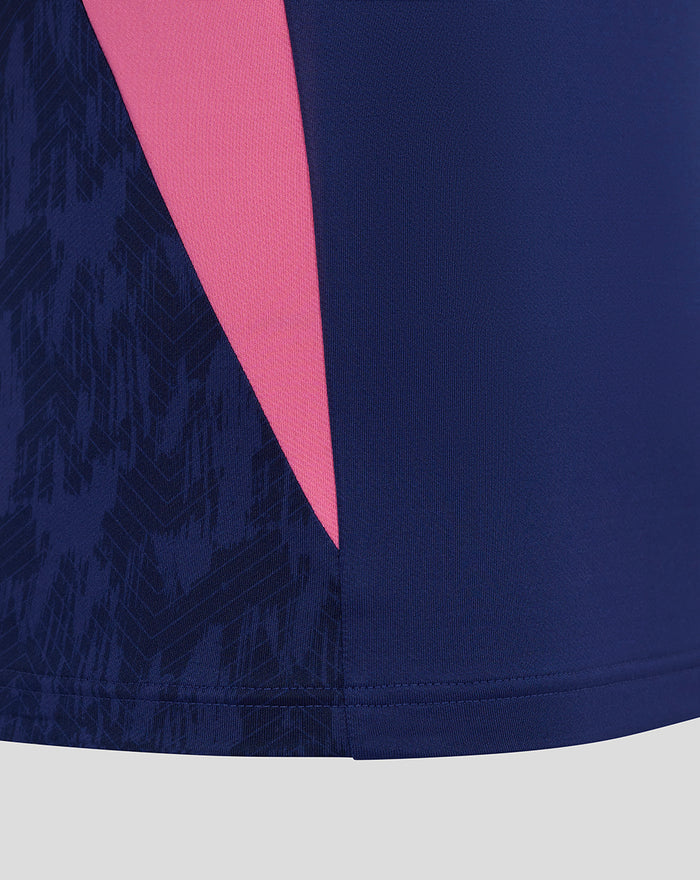 Close-up of blue training midlayer with a pink angled panel and textured sleeve pattern.