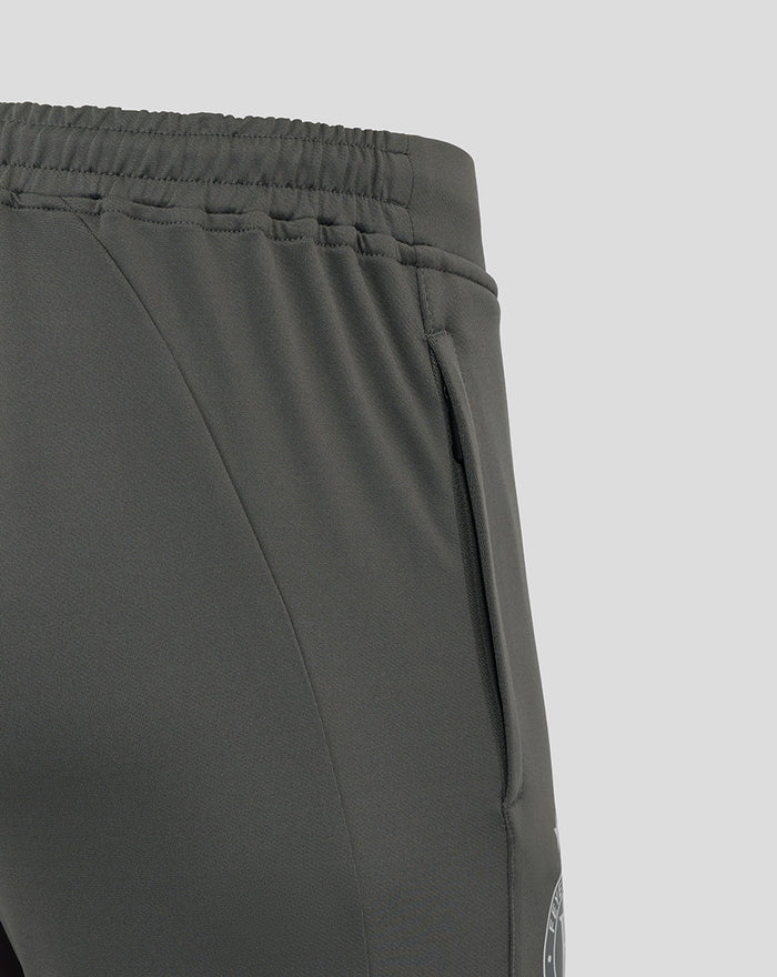 Close-up of side pocket and seam on the thigh of the gray training pants with branding.