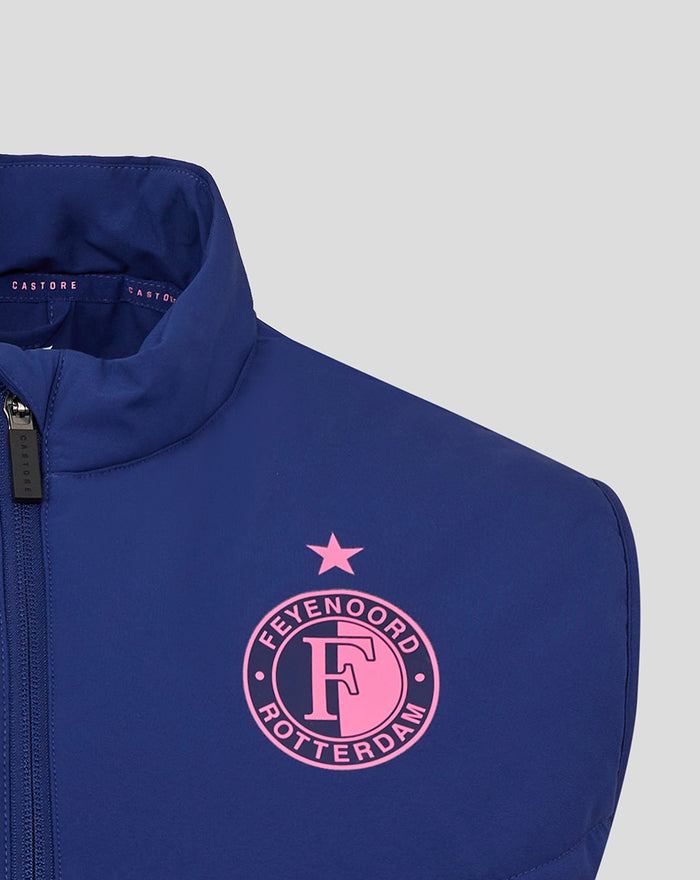 Close-up of the blue training vest chest showing a pink Feyenoord badge with a star above.