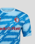 Detail van het Feyenoord Derde Matchday shirt in blauw met clublogo en MediaMarkt sponsor op een geblokt patroon