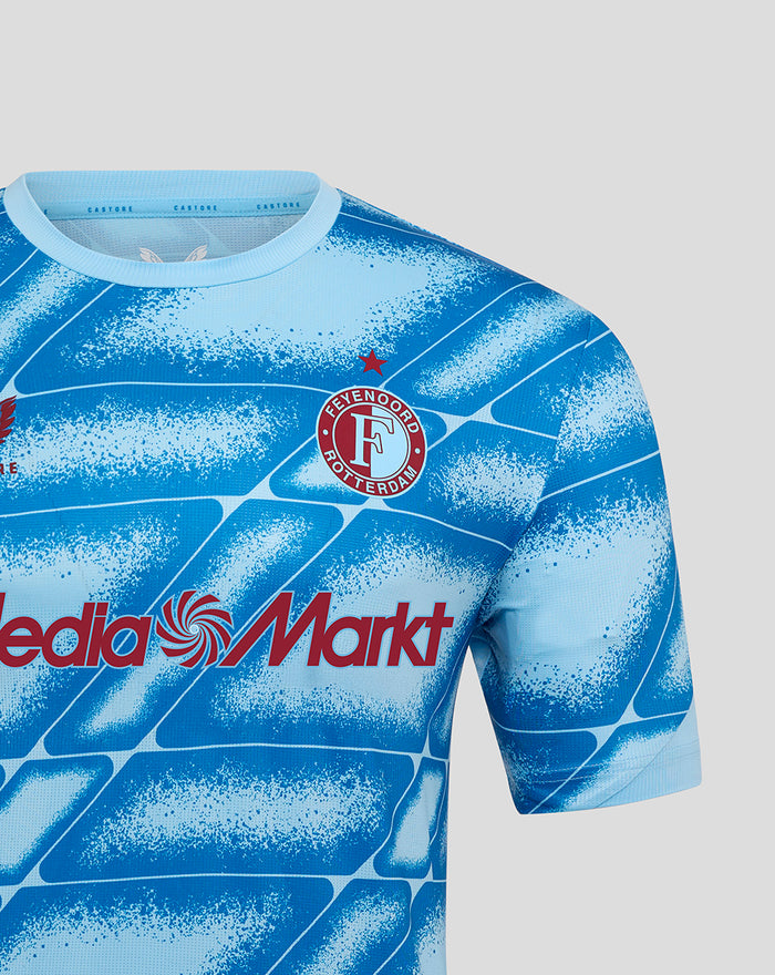 Detail van het Feyenoord Derde Matchday shirt in blauw met clublogo en MediaMarkt sponsor op een geblokt patroon