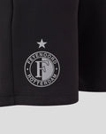 Close-up of black Feyenoord Travel Knit Short fabric featuring a white circular emblem with a star