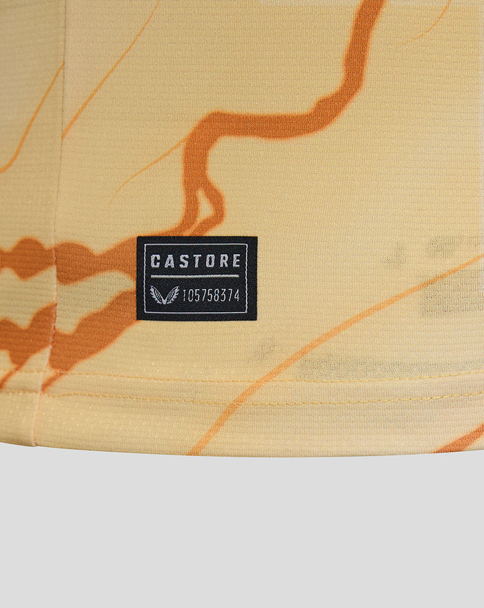 Close-up of Castore label on pale Feyenoord Vierde shirt fabric with orange abstract lines.