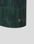Close-up of dark green Twaalfde shirt fabric with a small black Castore authenticity badge at the hem.