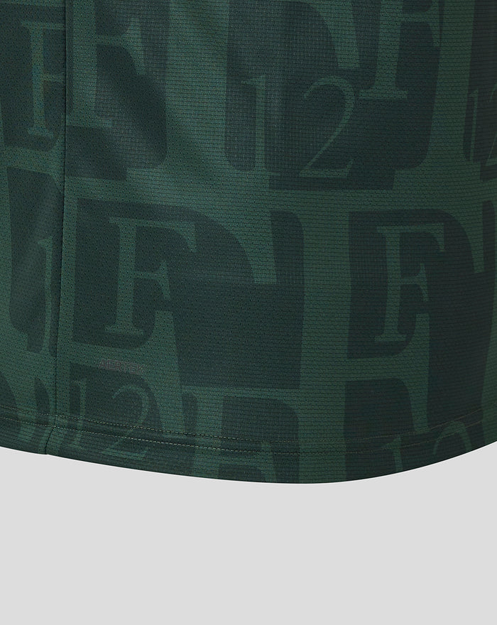 Close-up of dark green fabric showing an allover Feyenoord F and 12 motif with a visible seam.