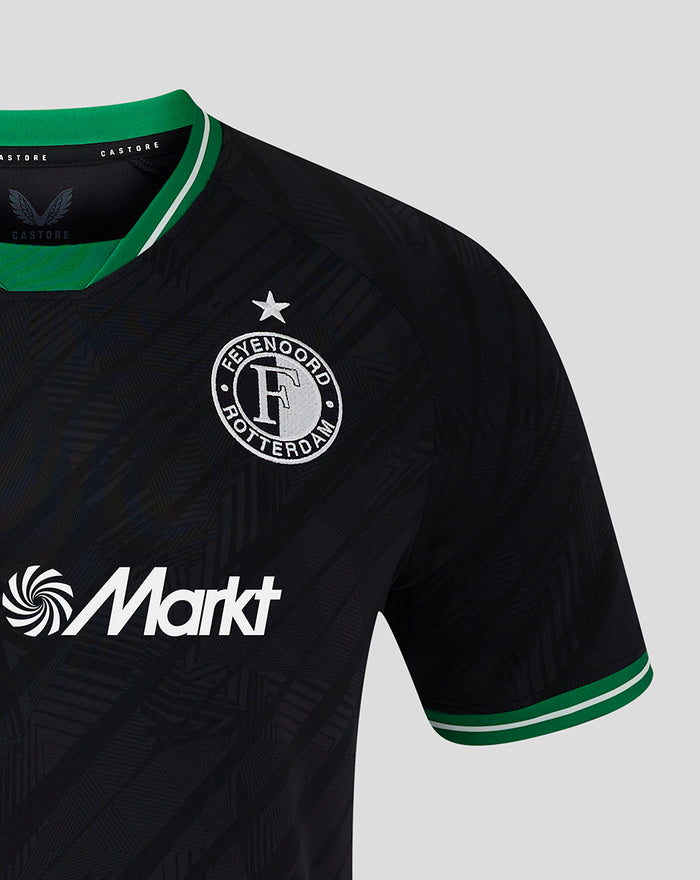 Close-up of the front of the black Feyenoord away shirt showing the crest on the left chest and bold sponsor logo across the torso with green trimmed sleeves.