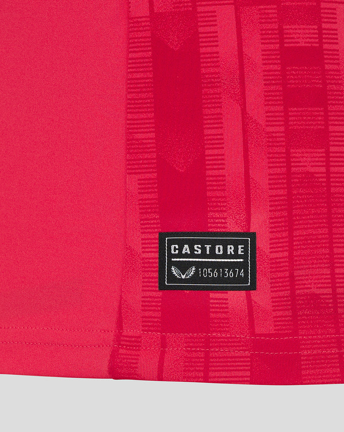 Close up of red Feyenoord keeper shirt fabric with a Castore label at the hem