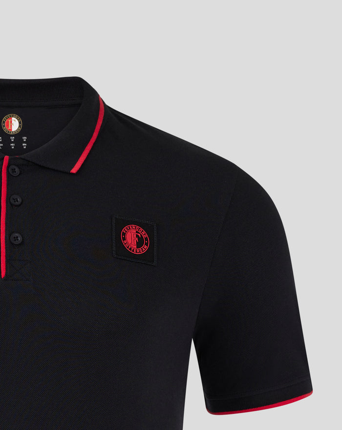 Chest close up of the black Feyenoord Classic Polo featuring the red Feyenoord badge on the left chest with red trim on the placket and sleeve edge.
