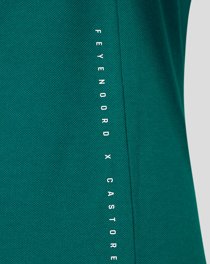 Teal green FEYENOORD x CASTORE cotton polo shirt with vertical white branding along the side seam.