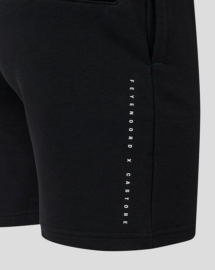 Close-up of the right leg showing vertical Feyenoord X Castore branding and teal stitching on black shorts