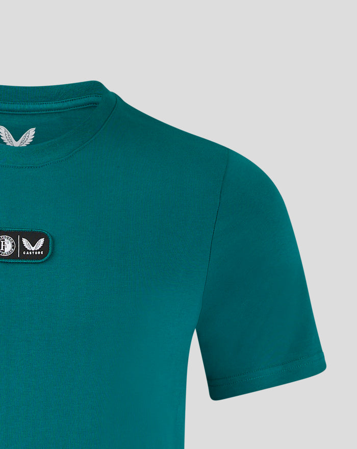 Close up of teal T shirt neckline and chest patch with logos.