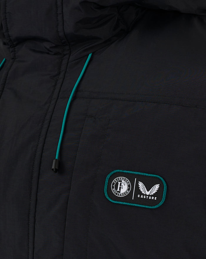 Close-up of a black Feyenoord Castore winter jacket with teal piping and a club badge on the chest pocket