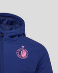 Close up of blue hooded training jacket showing pink Feyenoord crest on chest