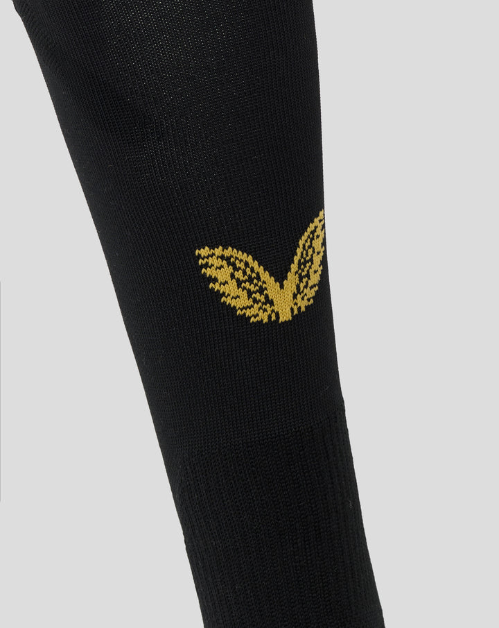 Close-up of black Feyenoord home sock with gold Castore emblem on the shin