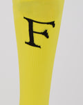 Close up of a large black logo on the yellow Feyenoord home goalkeeper sock