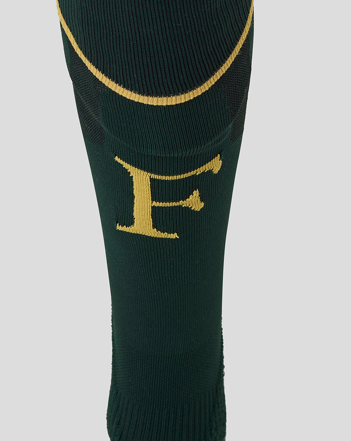 Close-up of dark green sock showing a gold F on the shin and a gold wing emblem on the calf
