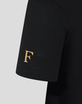 Close-up of a black T-shirt sleeve with a gold F emblem near the hem