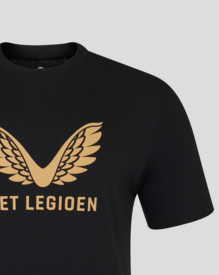 Close up of black T-shirt showing a gold wing emblem and partial gold text on the chest.