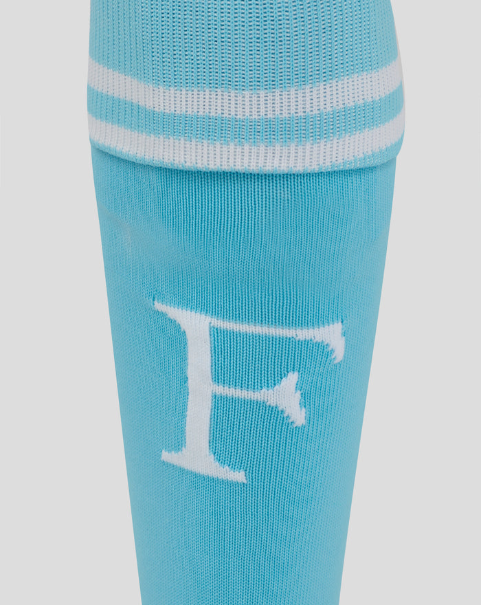 Close-up of light blue sock knit showing white stripes and logos